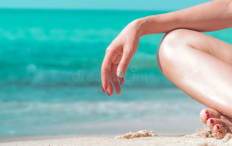 A mão do close up e o pé da mulher sentam-se na praia da areia no beira-mar com água verde esmeralda Mulher asiática nova feliz p fotos de stock A mão do close up e o pé da mulher sentam-se na praia da areia no beira-mar com água verde esmeralda Mulher asiática nova feliz p fotos de stock