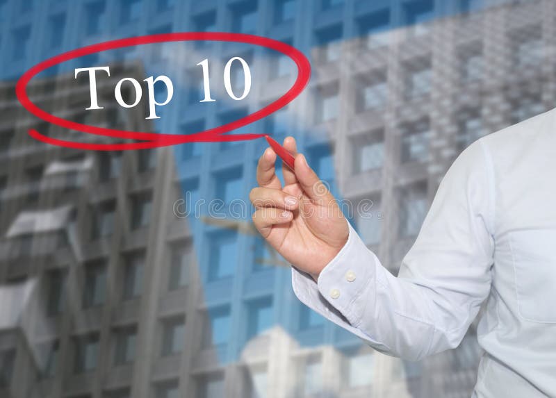 A mão do homem de negócios novo escreve a parte superior 10 da palavra em arranha-céus fotos de stock royalty free A mão do homem de negócios novo escreve a parte superior 10 da palavra em arranha-céus fotos de stock royalty free