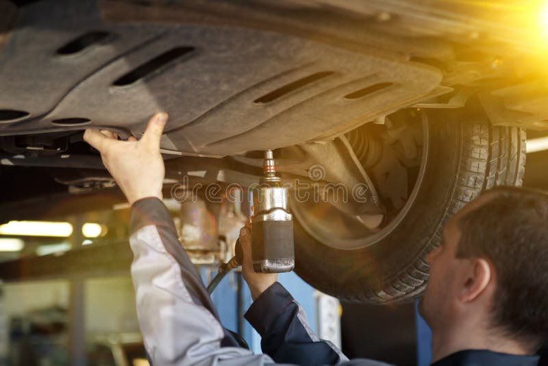 Mão do mecânico de carro com chave Garagem da reparação de automóveis imagem de stock Mão do mecânico de carro com chave Garagem da reparação de automóveis imagem de stock