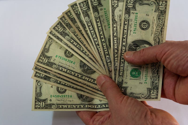 Mão dois que guarda um fã dos dólares foto de stock royalty free