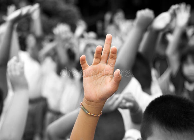 Hand in color raised among others hands in black and white background. Hand in color raised among others hands in black and white background