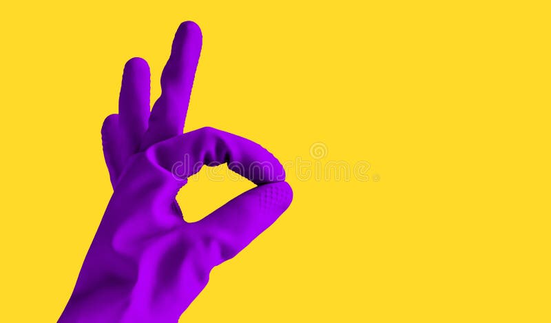 A mão na luva violeta de borracha mostra o sinal da aprovação, objeto isolado no fundo amarelo para o projeto com espaço da cópia foto de stock royalty free A mão na luva violeta de borracha mostra o sinal da aprovação, objeto isolado no fundo amarelo para o projeto com espaço da cópia foto de stock royalty free