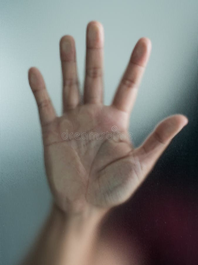 Mão obscura da mulher atrás do pânico de vidro geado da metáfora e da obscuridade negativa emocionais imagens de stock Mão obscura da mulher atrás do pânico de vidro geado da metáfora e da obscuridade negativa emocionais imagens de stock