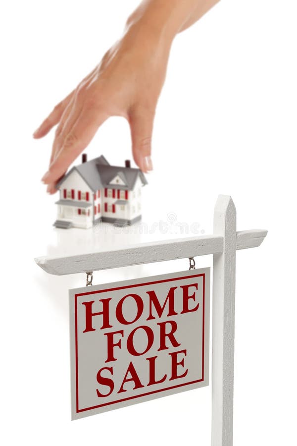 A mão que escolhe para casa com bens imobiliários assina dentro a parte dianteira fotografia de stock royalty free A mão que escolhe para casa com bens imobiliários assina dentro a parte dianteira fotografia de stock royalty free