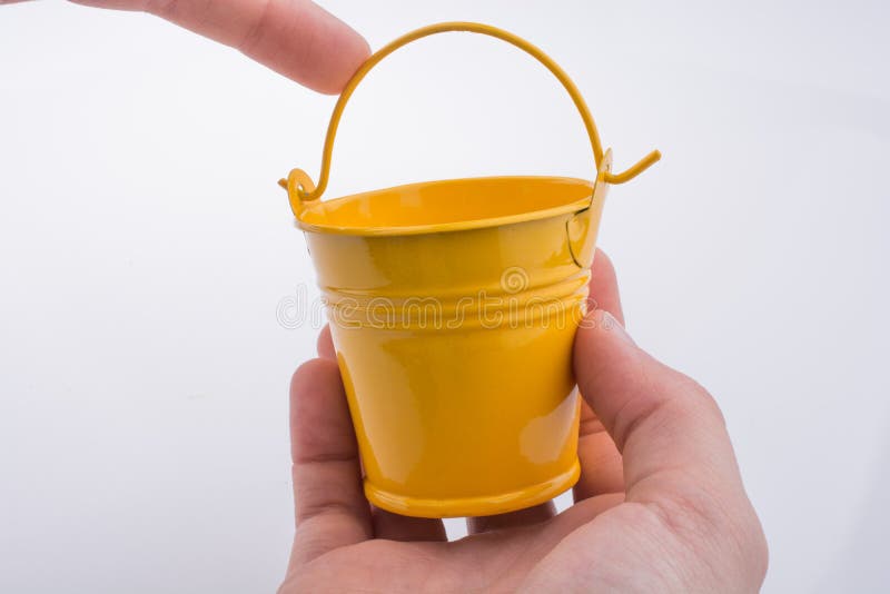Mão a segurar um balde imagem de stock royalty free