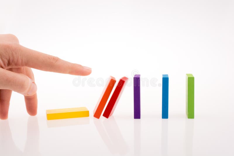 Mão a brincar com dominós coloridos imagem de stock