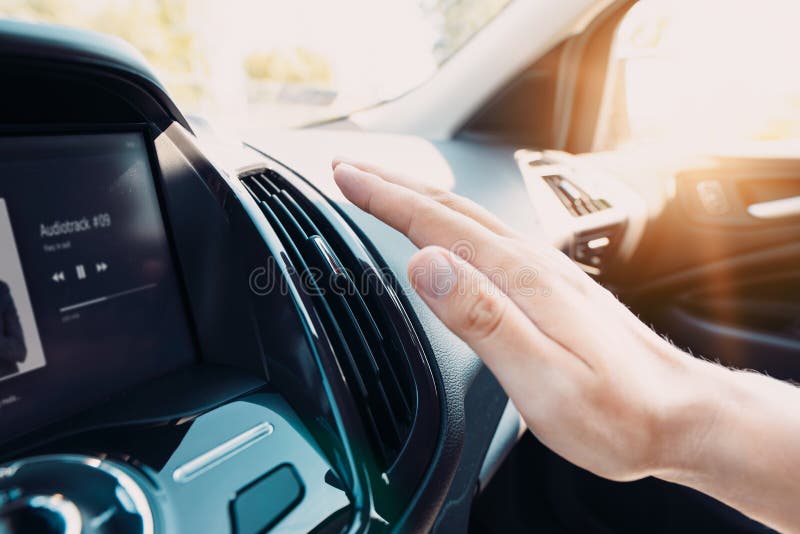 Mão que verifica o condicionador de ar no carro