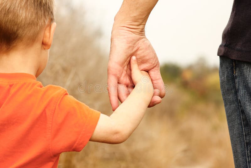 Mãos bonitas de uma criança e de um pai felizes no parque natural