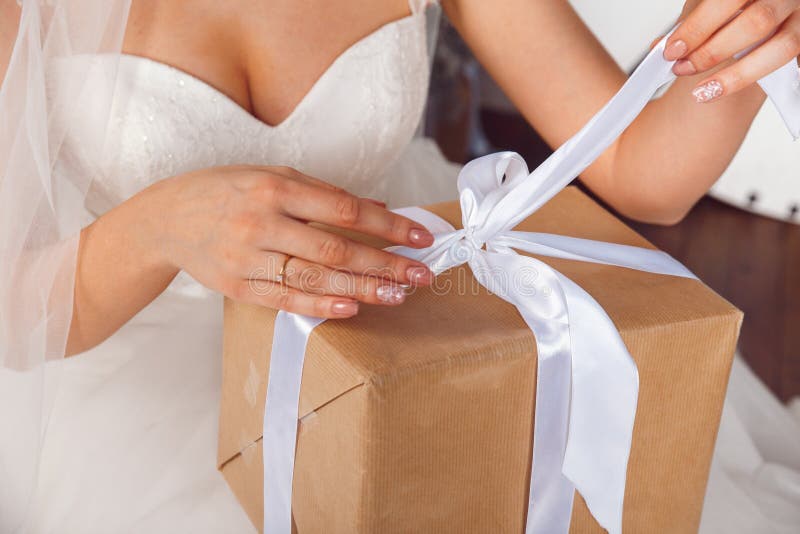 Mãos com a caixa de presente na celebração do casamento Retratos do estúdio da noiva bonita com presente Noiva que guarda o prese fotografia de stock Mãos com a caixa de presente na celebração do casamento Retratos do estúdio da noiva bonita com presente Noiva que guarda o prese fotografia de stock