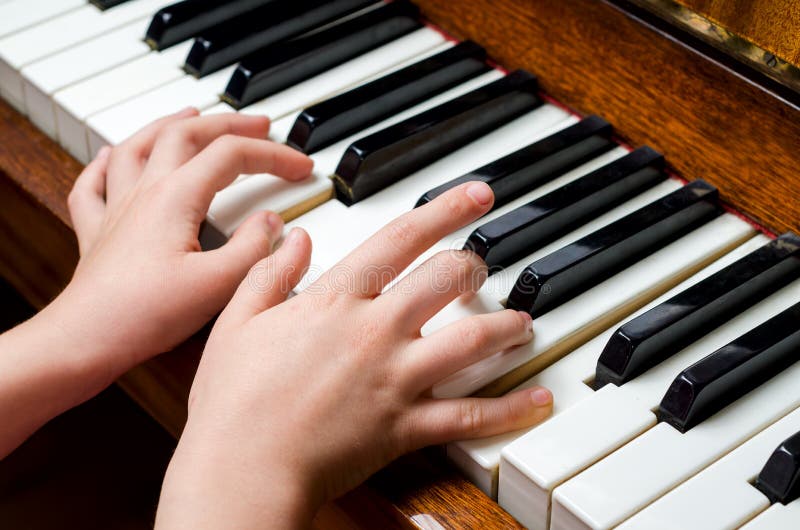 Mãos da criança que jogam o piano fotos de stock Mãos da criança que jogam o piano fotos de stock