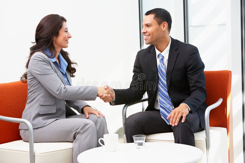 Mãos de And Businesswoman Shaking do homem de negócios após o encontro imagem de stock royalty free Mãos de And Businesswoman Shaking do homem de negócios após o encontro imagem de stock royalty free