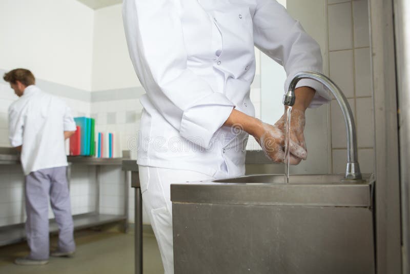 Mãos de lavagem do cozinheiro chefe antes do cozinheiro imagens de stock Mãos de lavagem do cozinheiro chefe antes do cozinheiro imagens de stock