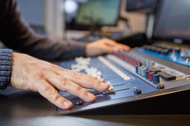 Mãos de um homem em ajustar um console da produção fotos de stock Mãos de um homem em ajustar um console da produção fotos de stock
