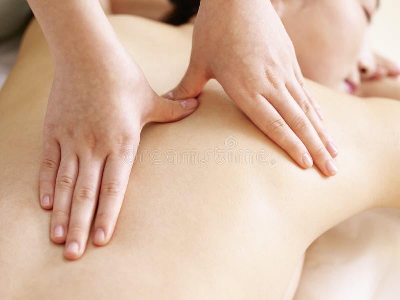 Mãos do massagista que executam a massagem na mulher asiática nova fotografia de stock royalty free Mãos do massagista que executam a massagem na mulher asiática nova fotografia de stock royalty free