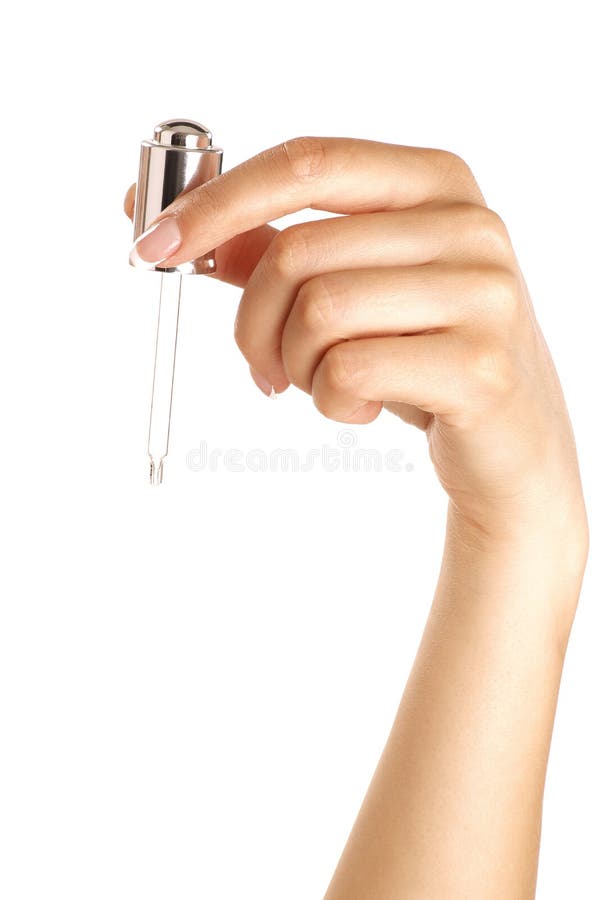 Mãos fêmeas bonitas perfeitas com um conta-gotas imagens de stock Mãos fêmeas bonitas perfeitas com um conta-gotas imagens de stock