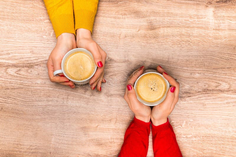 Mãos fêmeas que guardam um copo do café quente imagens de stock Mãos fêmeas que guardam um copo do café quente imagens de stock