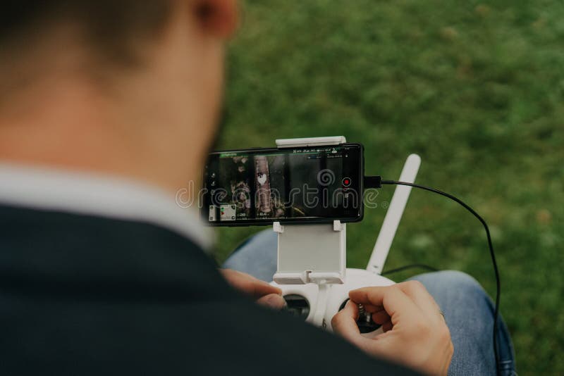 Mãos masculinas que guardam o controlador remoto para a operação de voo do zangão fotografia de stock Mãos masculinas que guardam o controlador remoto para a operação de voo do zangão fotografia de stock