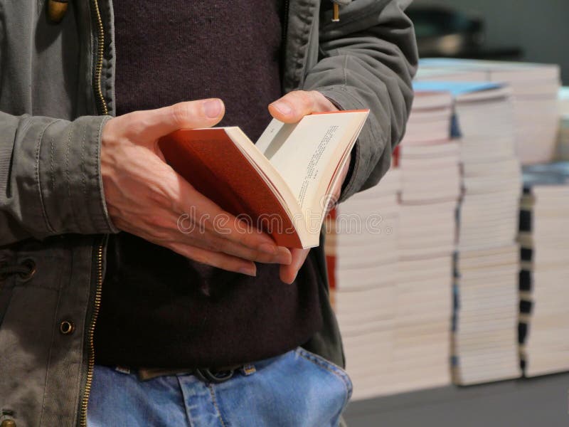 Mãos masculinas que guardam um fim aberto do livro acima da vista imagens de stock Mãos masculinas que guardam um fim aberto do livro acima da vista imagens de stock