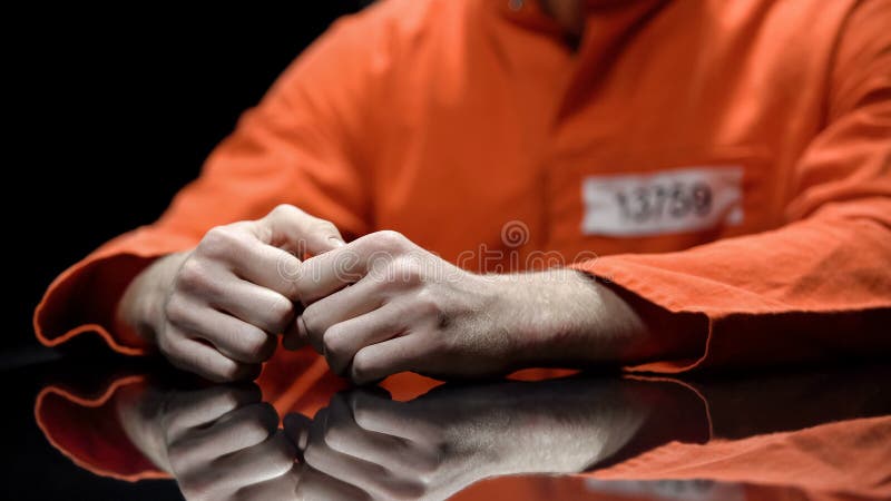 Mãos prendidas close up da pessoa, prisioneiro que fala ao advogado durante a interrogação
