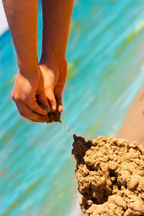 Mãos a construir um castelo de areia imagens de stock royalty free