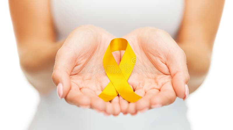 Mãos que guardam a fita da conscientização do câncer do ouro amarelo