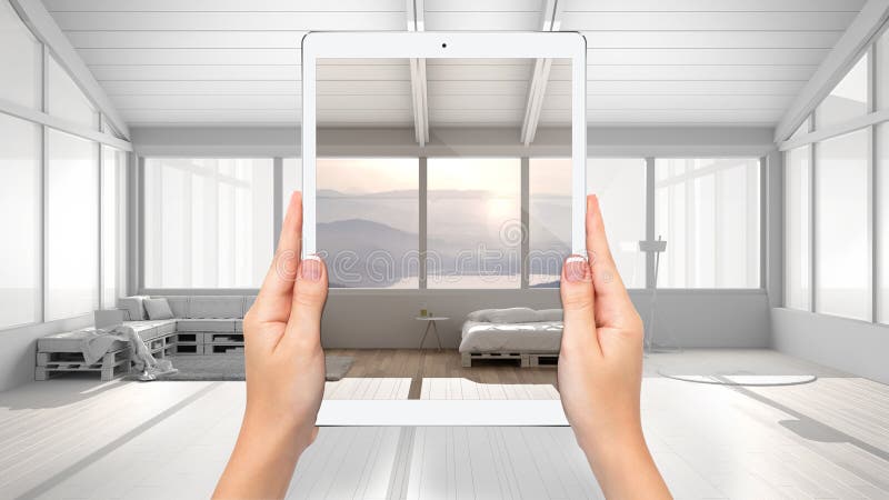 Mãos segurando tablet que mostra quarto moderno com sofá, fundo de projeto totalmente em branco, conceito de realidade aumentada imagem de stock