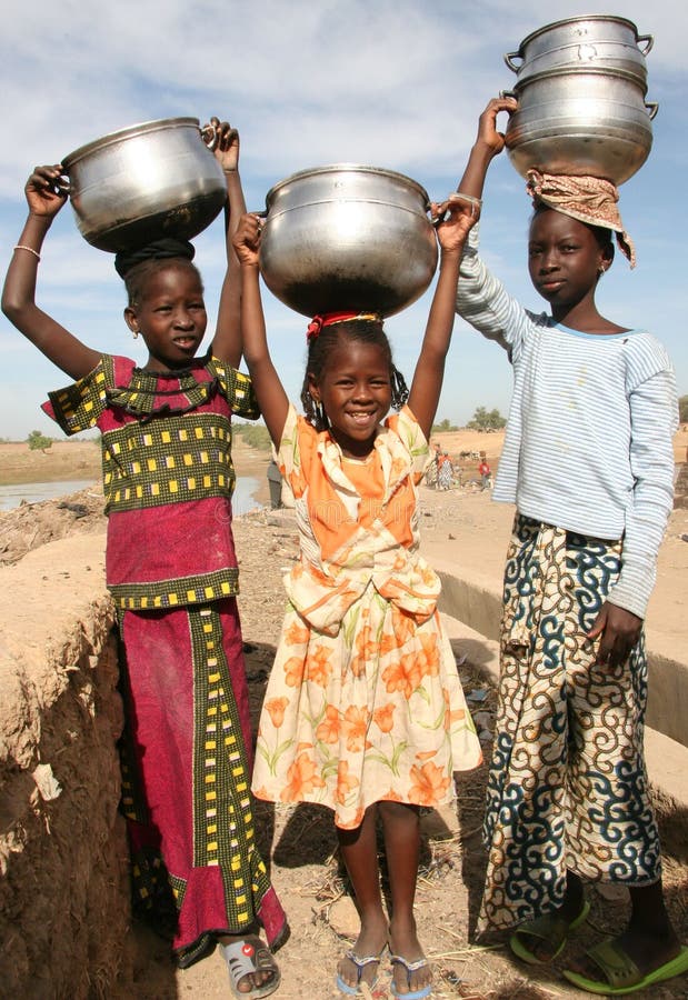 Fulani girls in Africa carrying pots with milk to the market. Fulani girls in Africa carrying pots with milk to the market