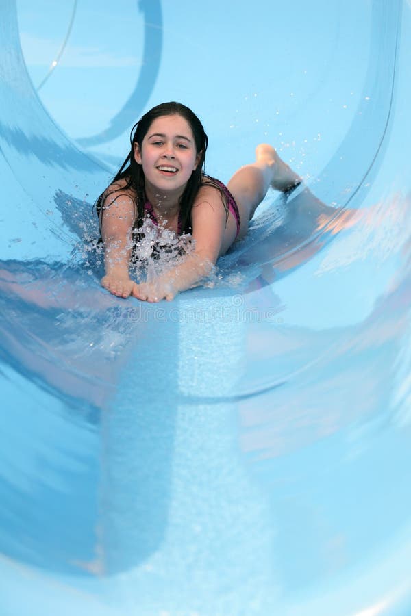 Girl smiling and having fun sliding down a water slide. Girl smiling and having fun sliding down a water slide