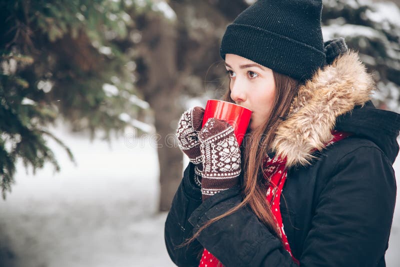 Mädchen, das heißen Tee im Winterwald trinkt lizenzfreies stockfoto Mädchen, das heißen Tee im Winterwald trinkt lizenzfreies stockfoto