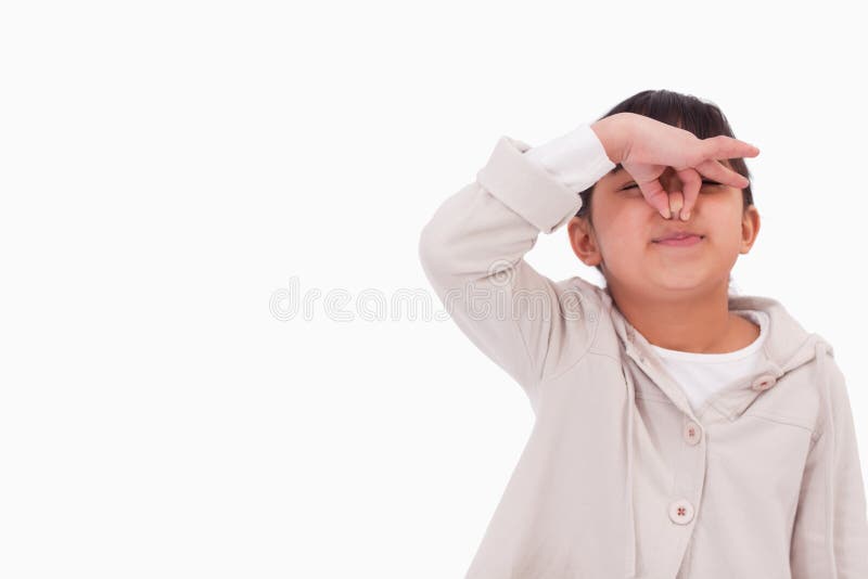 Girl pinching her nose against a white background. Girl pinching her nose against a white background