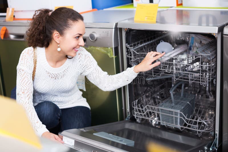 Mädchen, das moderne Spülmaschine vorwählt stockfotografie Mädchen, das moderne Spülmaschine vorwählt stockfotografie