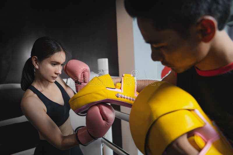 Mädchen, das Trittübung während des kickboxing Trainings mit persönlichem Trainer tut lizenzfreie stockbilder Mädchen, das Trittübung während des kickboxing Trainings mit persönlichem Trainer tut lizenzfreie stockbilder