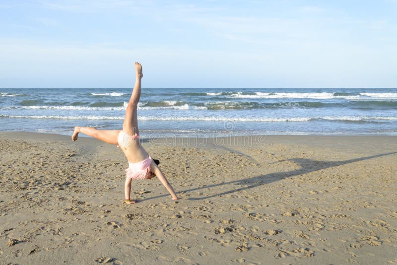 Mädchen, das Wagenrad auf dem Strand tut stockbilder Mädchen, das Wagenrad auf dem Strand tut stockbilder