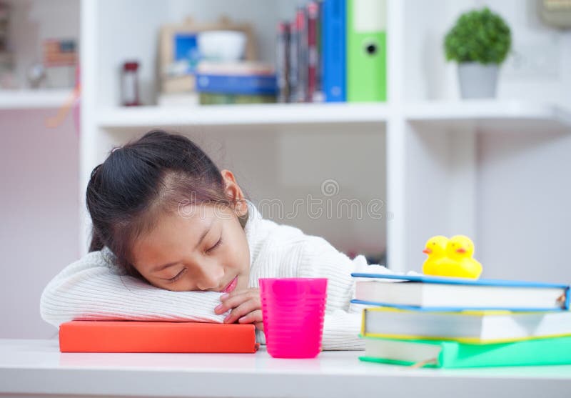 Mädchen, das zu Hause ein Buch liest Mädchen, das bei Tisch auf Reinraum studing ist lizenzfreies stockbild Mädchen, das zu Hause ein Buch liest Mädchen, das bei Tisch auf Reinraum studing ist lizenzfreies stockbild