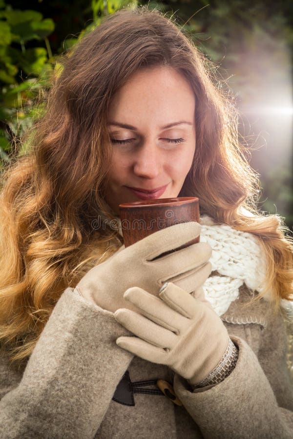 Mädchen in der warmen Kleidung auf Herbstpark genießend mit einer Schale heißen t stockfotografie Mädchen in der warmen Kleidung auf Herbstpark genießend mit einer Schale heißen t stockfotografie