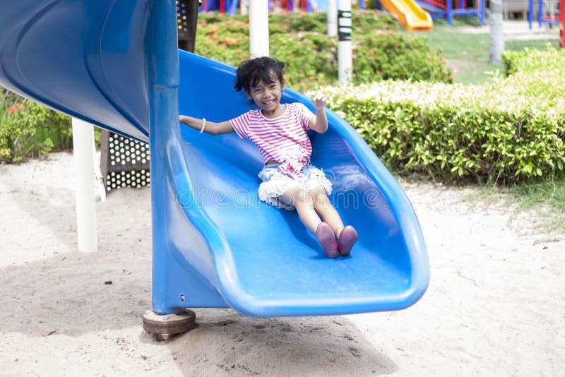 Mädchen, die das Dia auf dem Spielplatz spielen stockbilder Mädchen, die das Dia auf dem Spielplatz spielen stockbilder