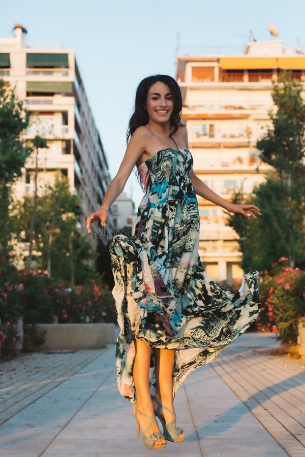 Mädchen in einem Kleid, das auf einen Straßenhintergrund springt lizenzfreie stockfotografie