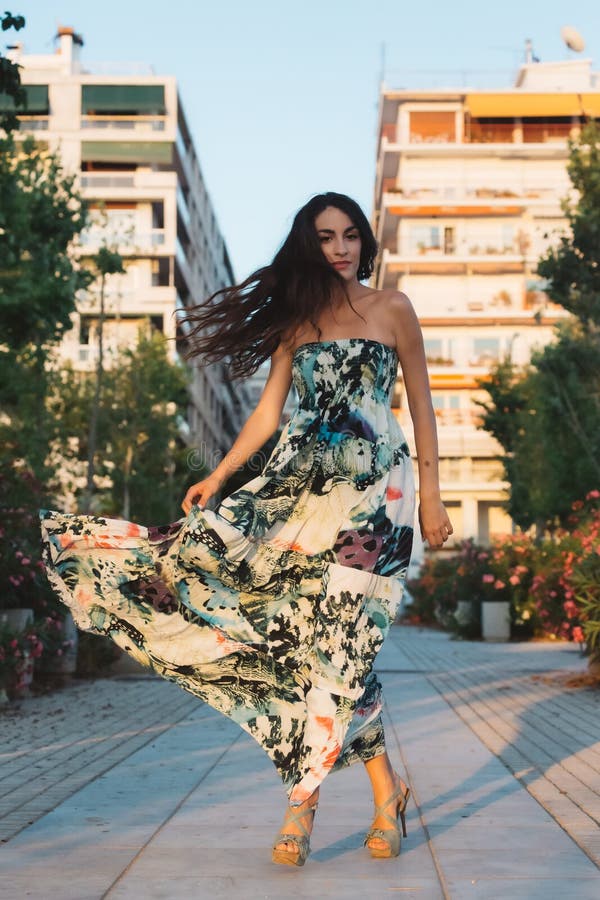 Mädchen in einem Kleid, das in der Bewegung in einem Straßenhintergrund darstellt lizenzfreies stockbild
