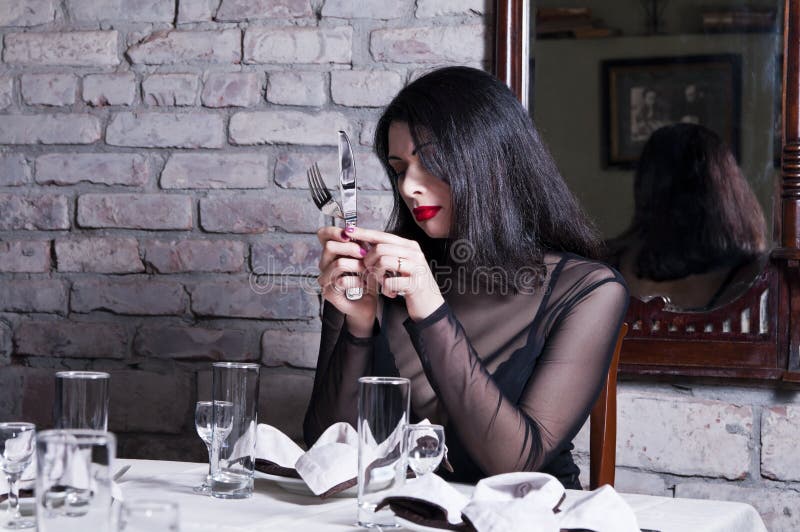 Mädchen an einem Restauranttisch lizenzfreie stockfotos Mädchen an einem Restauranttisch lizenzfreie stockfotos