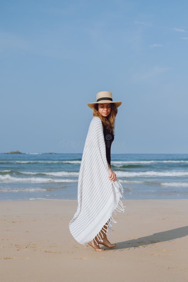 Mädchen in einem schwarzen Badeanzug und in einem Hut gehend auf den Strand stockfotos Mädchen in einem schwarzen Badeanzug und in einem Hut gehend auf den Strand stockfotos