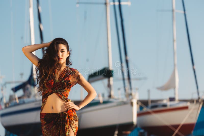 Mädchen in einer Strandklage vor Boot stockfotografie
