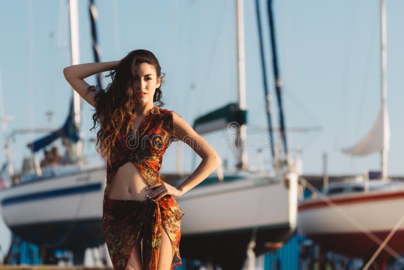 Mädchen in einer Strandklage vor Boot stockbild