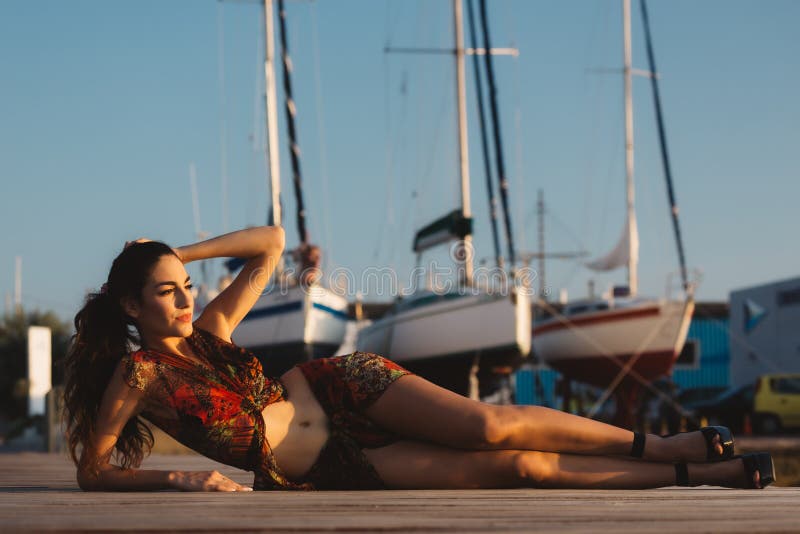 Mädchen in einer Strandklage vor Boot stockbild