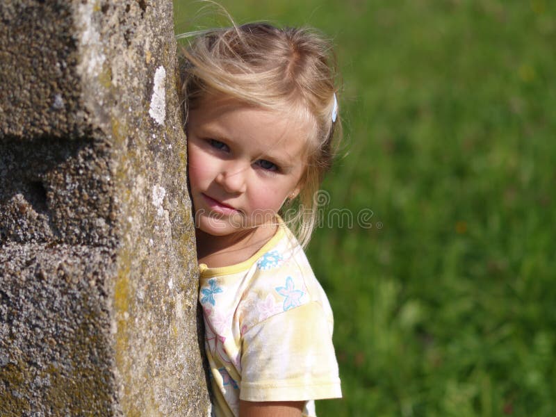 Mädchen hinter dem Steinschiffspoller lizenzfreies stockfoto Mädchen hinter dem Steinschiffspoller lizenzfreies stockfoto
