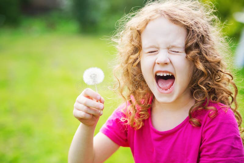 Mädchen hält einen Löwenzahn und niest lizenzfreies stockfoto Mädchen hält einen Löwenzahn und niest lizenzfreies stockfoto
