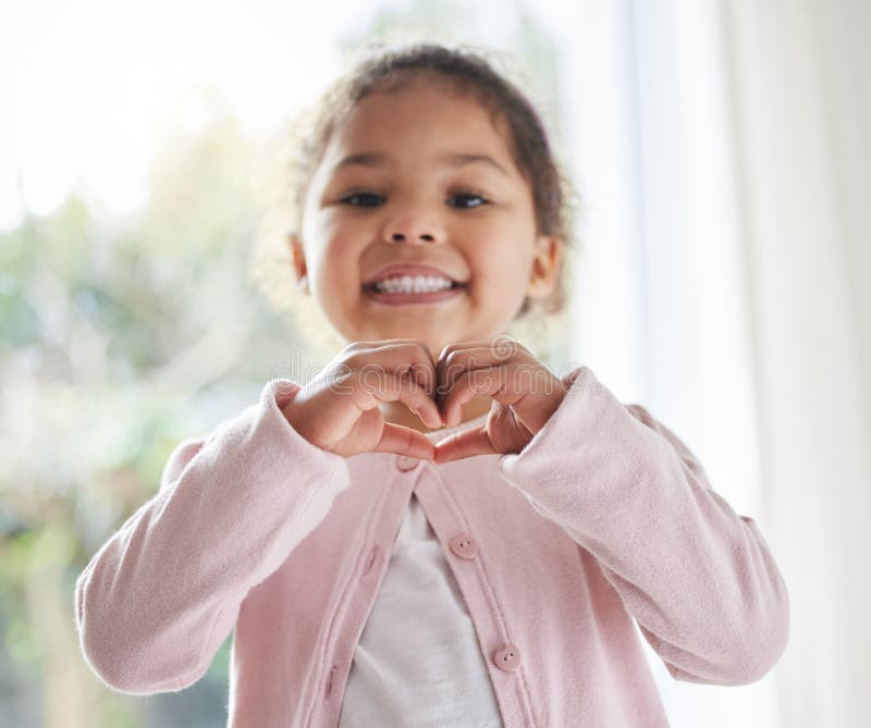 Mädchen Kind und Herz Hand in Haus Portrait Liebe Symbol und Zeichen für Freundlichkeit oder Frieden in Lounge. Männliche stockbild