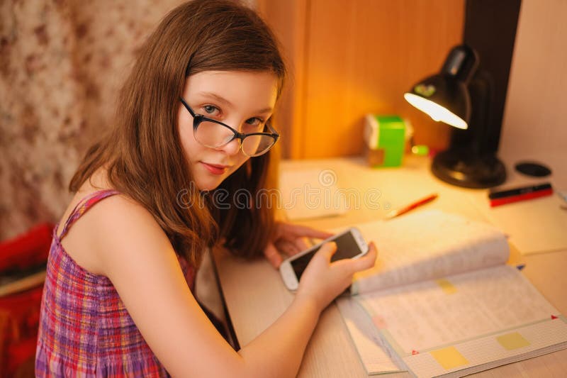 M?dchen mit den Gl?sern, die Lektionen gl?ttend tun lizenzfreie stockfotos M?dchen mit den Gl?sern, die Lektionen gl?ttend tun lizenzfreie stockfotos