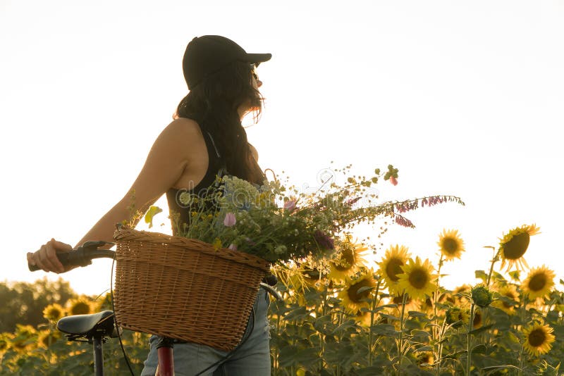 Mädchen mit einem Fahrrad und ein Korb von Blumen lizenzfreies stockfoto Mädchen mit einem Fahrrad und ein Korb von Blumen lizenzfreies stockfoto