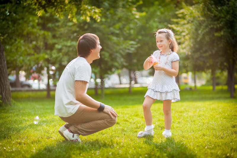 Mädchen mit ihrem Vater im Park lizenzfreies stockfoto Mädchen mit ihrem Vater im Park lizenzfreies stockfoto