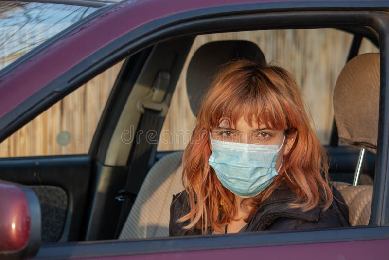 Mädchen mit medizinischer Maske im Auto Frauen tragen eine Maske, geschrieben COVID-19, um sie vor dem Corona-Virus zu schützen A stockbilder Mädchen mit medizinischer Maske im Auto Frauen tragen eine Maske, geschrieben COVID-19, um sie vor dem Corona-Virus zu schützen A stockbilder
